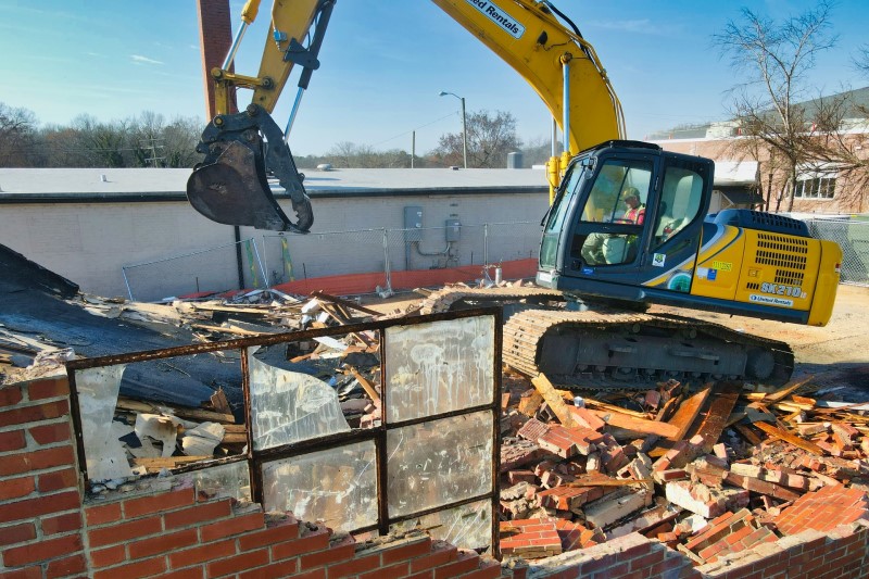 Crew loading demolition debris onto a junk removal truck